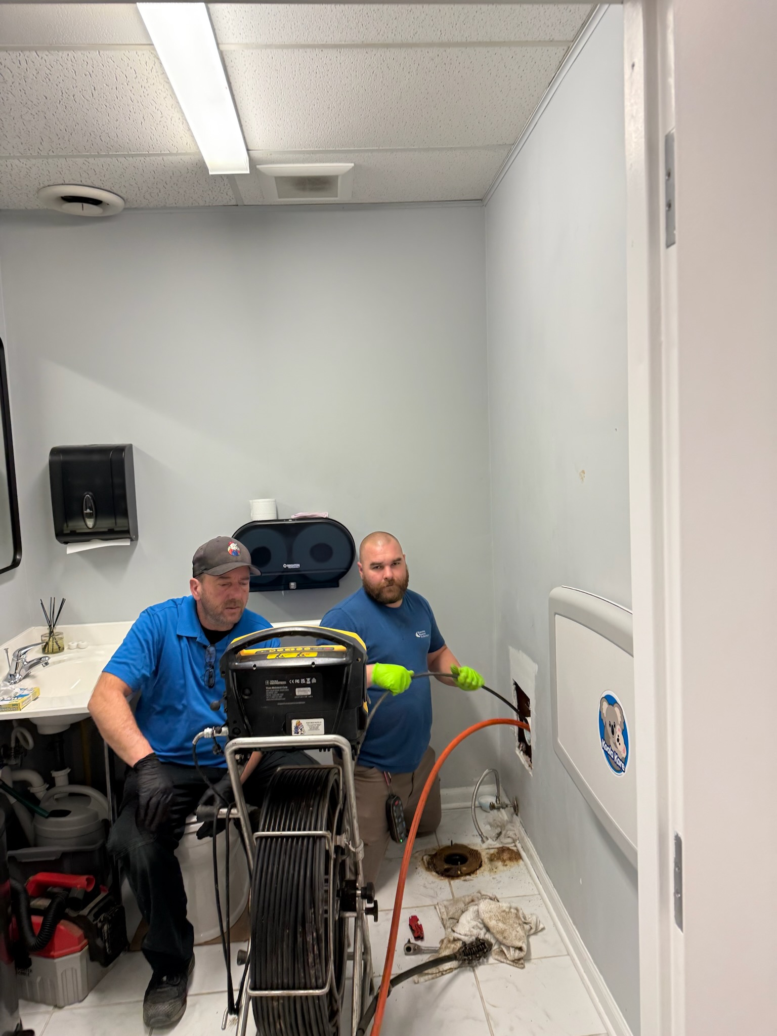 Two Wooley technicians at the cleanout — push-camera reel deployed, scoping a Central Ohio lateral before quoting the method